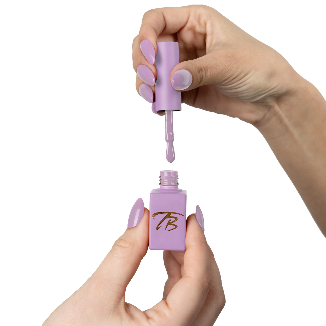 Hand holding a purple nail polish bottle with a dropper, white background